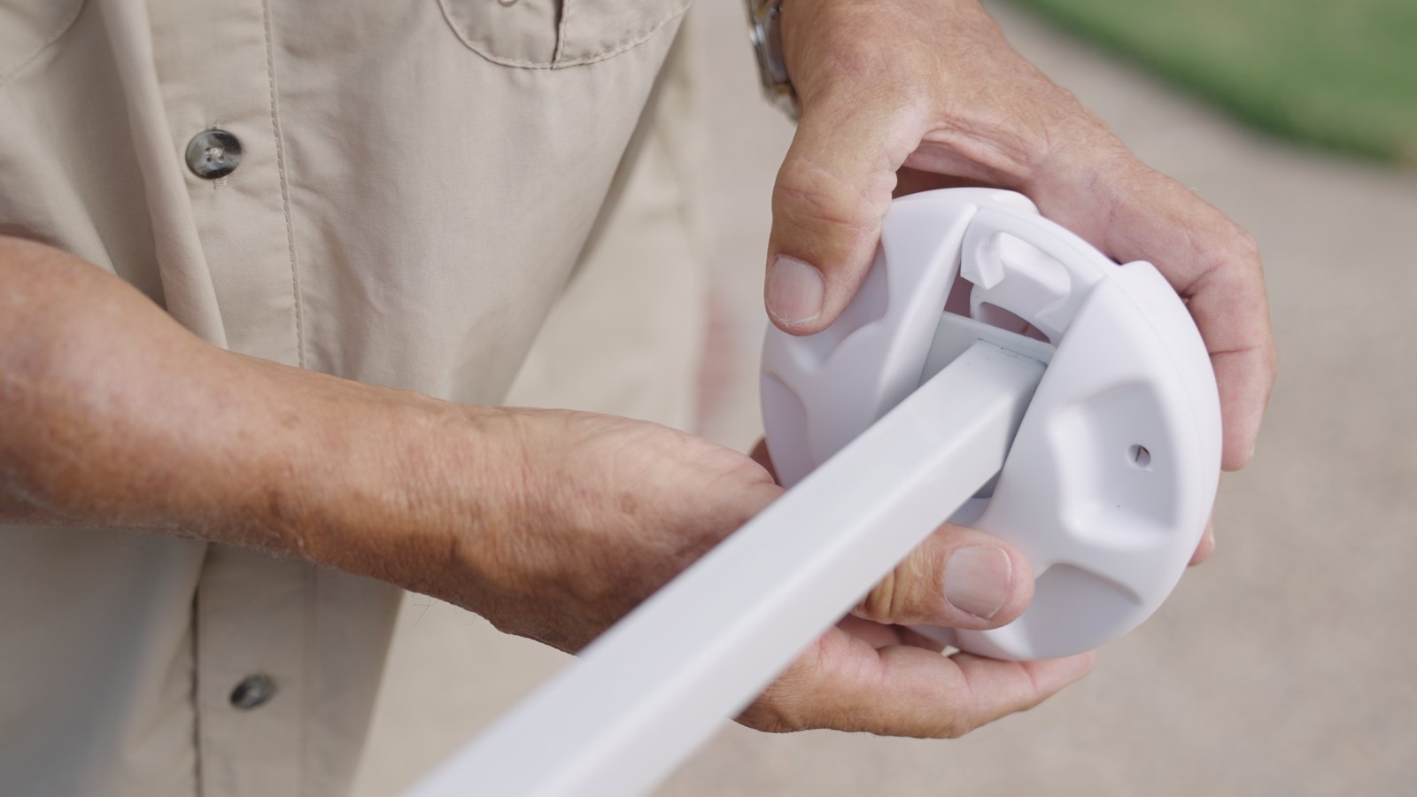 Close-up of a Canopy Turtle being bolted onto the bottom of a pop-up canopy leg for pool shade install.